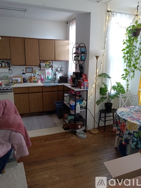 A kitchen with wooden cabinets and a table with a floral tablecloth.