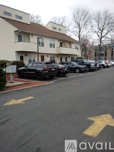 A parking lot with cars parked in front of a building.