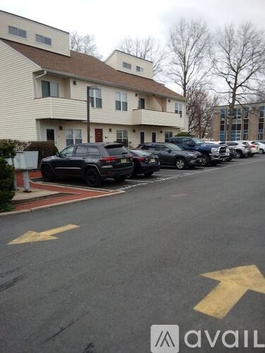 A parking lot with cars parked in front of a building.