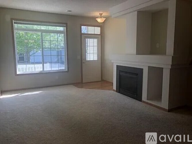A living room with a fireplace and a large window.