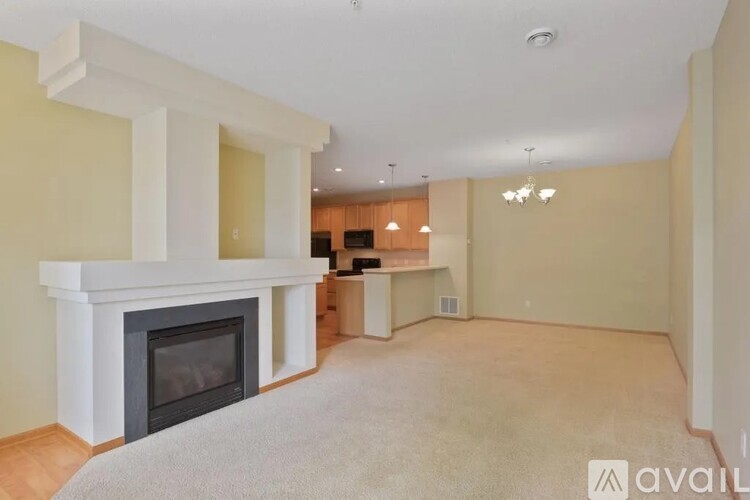 A living room with a fireplace and a carpet on the floor.