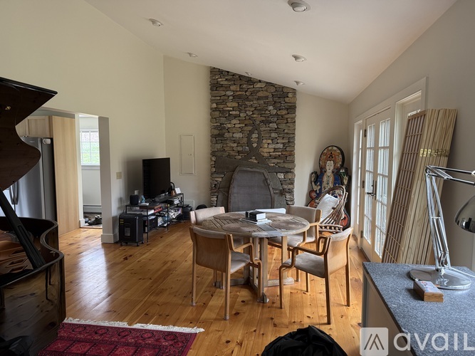 A living room with a wooden floor and a stone wall.