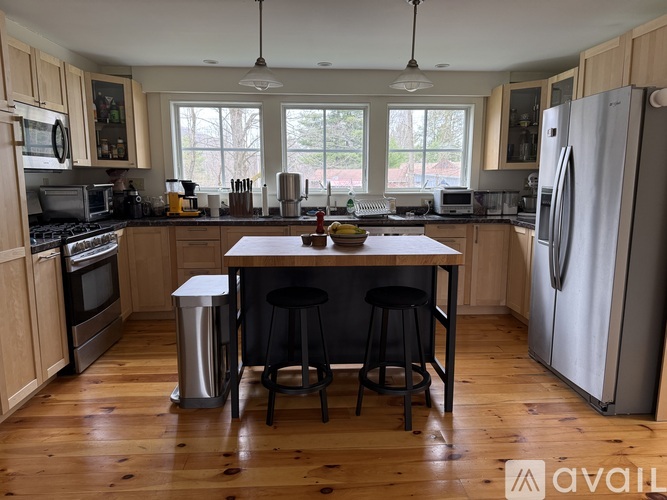 A kitchen with wooden floors and a large island in the middle.