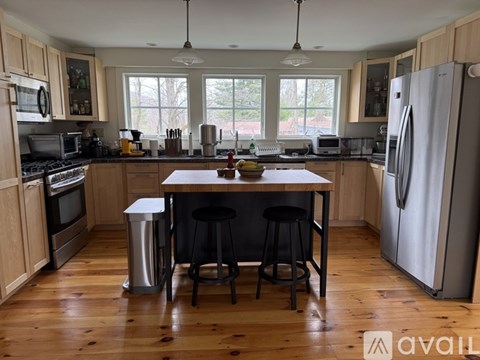A kitchen with wooden floors and a large island in the middle.