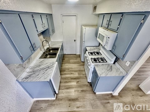 A kitchen with blue cabinets and a marble countertop.