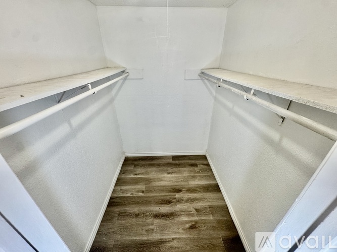 Empty room with white walls and wooden floor.