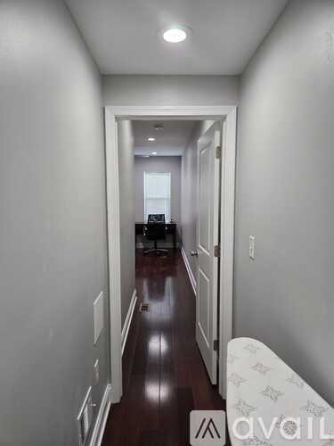 A long hallway with a white door at the end.