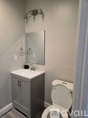 A bathroom with a white sink and a toilet.