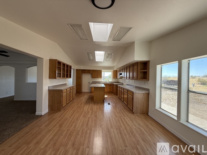 A spacious kitchen and dining area with wooden floors and ceiling lights.