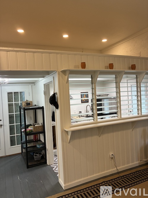 A kitchen with a white cabinet and a black shelf.