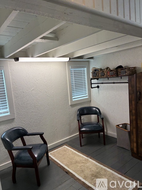 Two chairs are sitting in a room with a rug in between them.