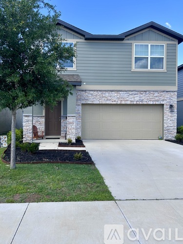 A house with a grey garage door and a brown front door.