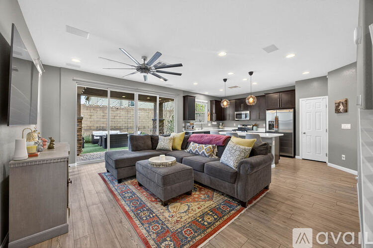 A living room with a grey couch and a ceiling fan.