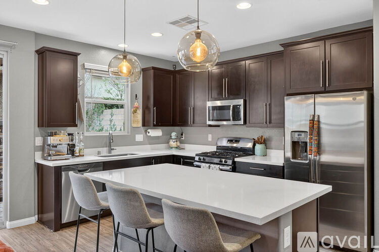 A modern kitchen with a center island and pendant lights.