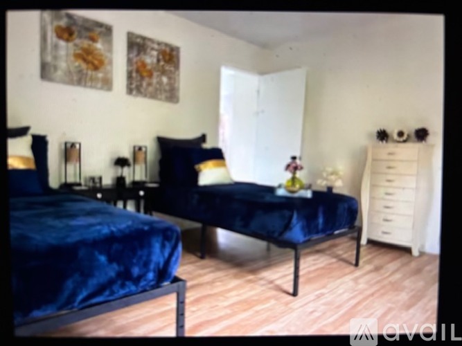 A bedroom with two beds and a dresser.