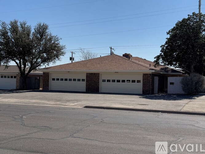 A house with a brown roof and three garages is available for sale.
