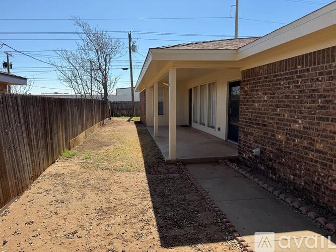 A house with a brown fence and a brick wall.