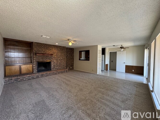 A living room with a fireplace and a ceiling fan.
