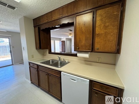 A kitchen with wooden cabinets and a white dishwasher.