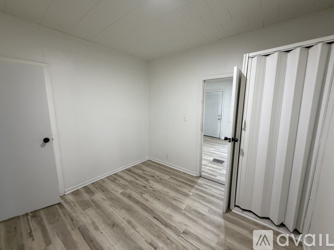 A room with a white door and a white wall.