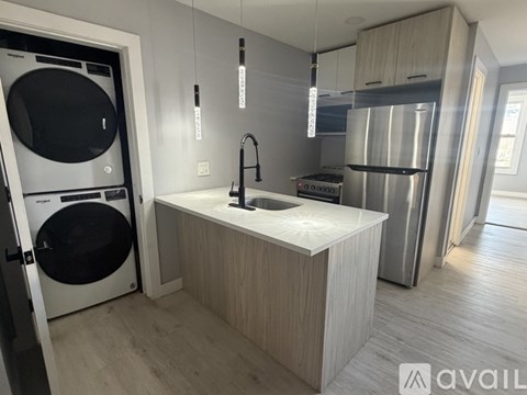A modern kitchen with a washing machine and refrigerator built into the cabinetry.