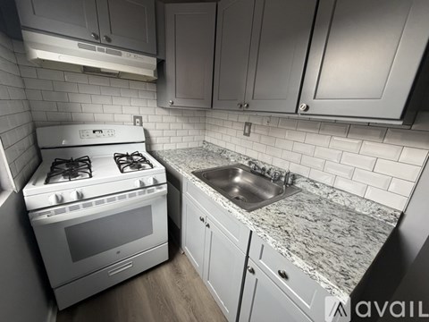 A kitchen with a white stove and a granite countertop.