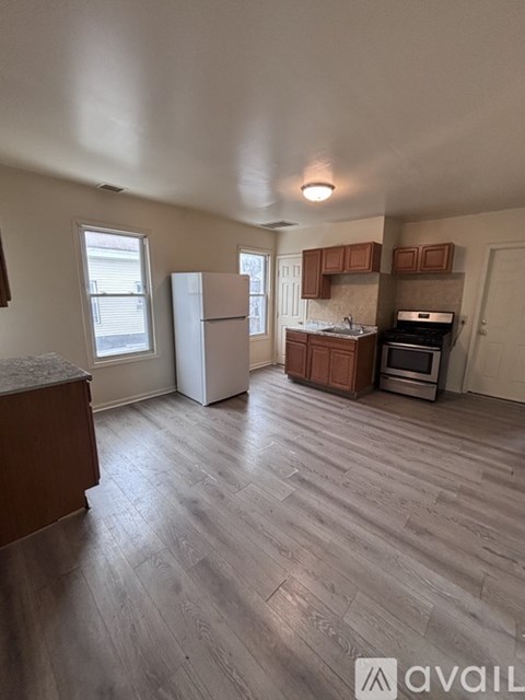 A kitchen area with a refrigerator, microwave, oven, and cabinets.