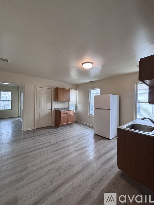 A kitchen with wooden floors and white appliances.