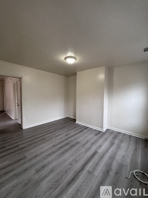 A room with wooden flooring and white walls.