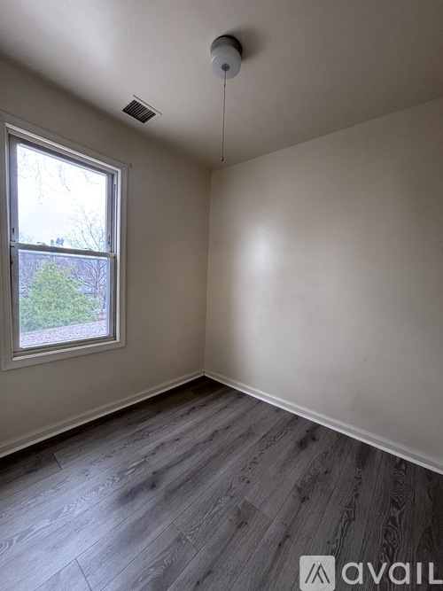 A room with a window and wooden flooring.