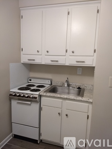 A kitchen with white cabinets and a stove top oven.