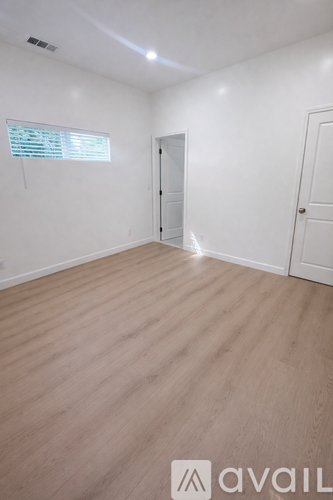 A room with wooden flooring and two white doors.
