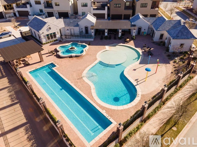 A swimming pool surrounded by a fence and a building in the background.