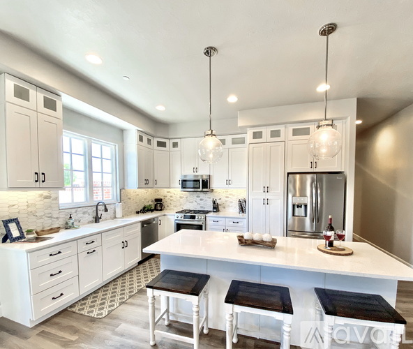 A modern kitchen with white cabinets and a central island.