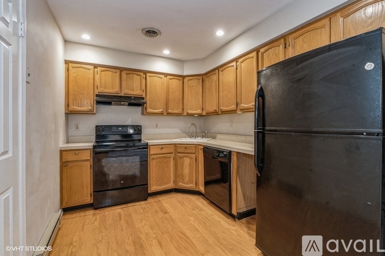 A kitchen with wooden cabinets and black appliances.
