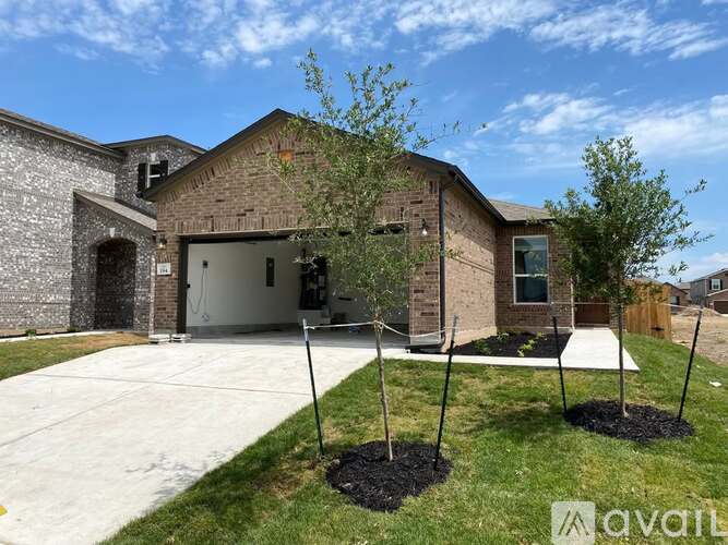 A house with a driveway and a tree in front.