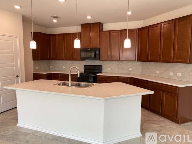 A kitchen with brown cabinets and a white island.
