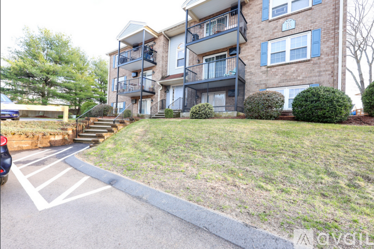 Apartment building with a parking lot in front.