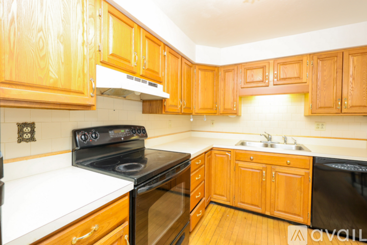 A kitchen with wooden cabinets and a black stove top oven.