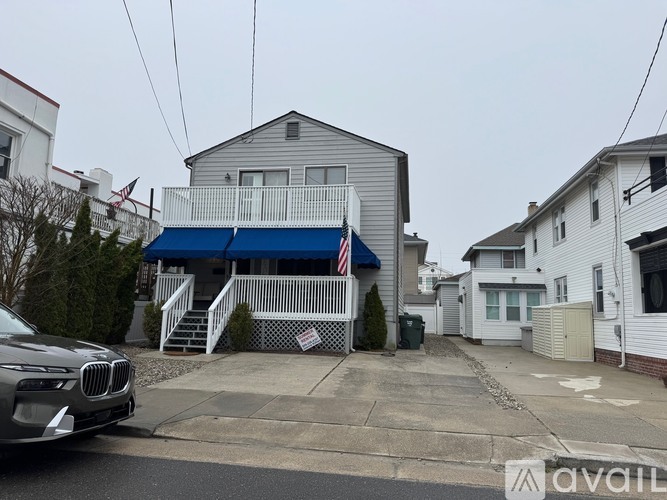 A house with a blue awning is for sale.