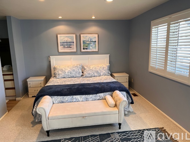 A bedroom with a large bed and a bench.