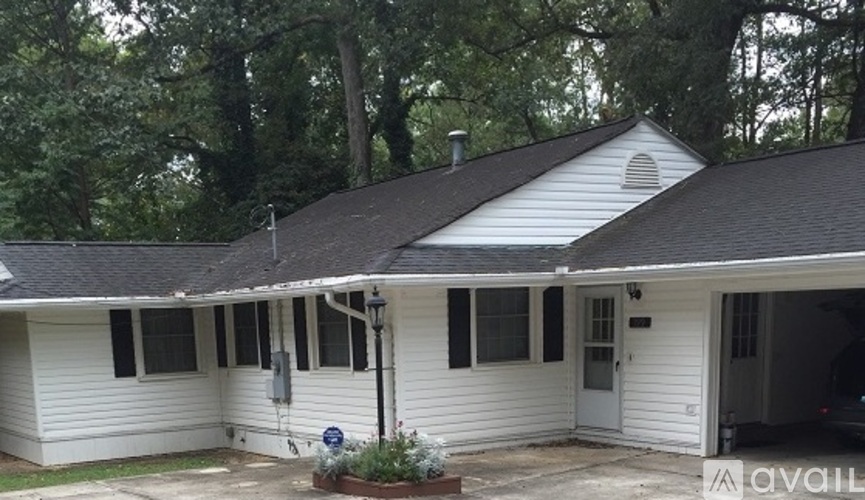 A white house with a black roof and a garage door.
