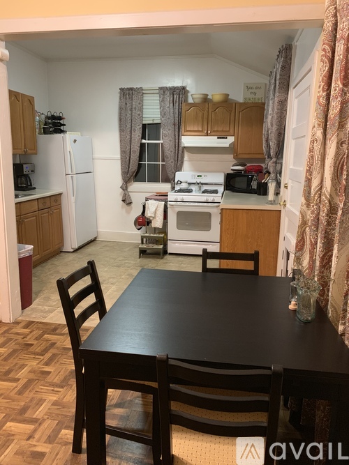 A kitchen with a table and chairs in the foreground.