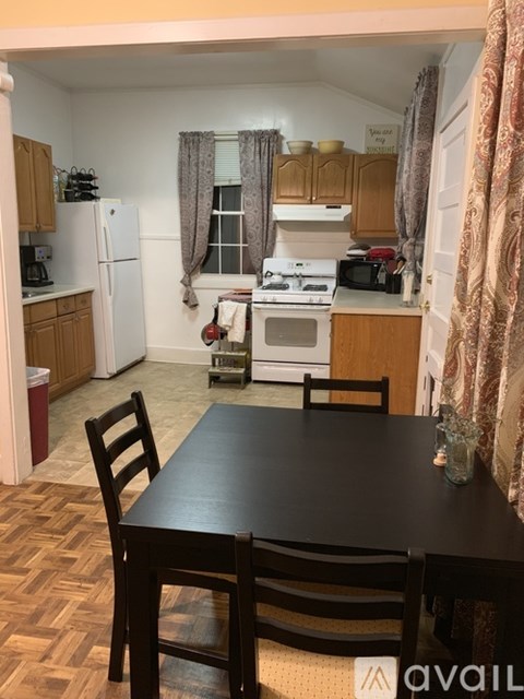 A kitchen with a table and chairs in the foreground.