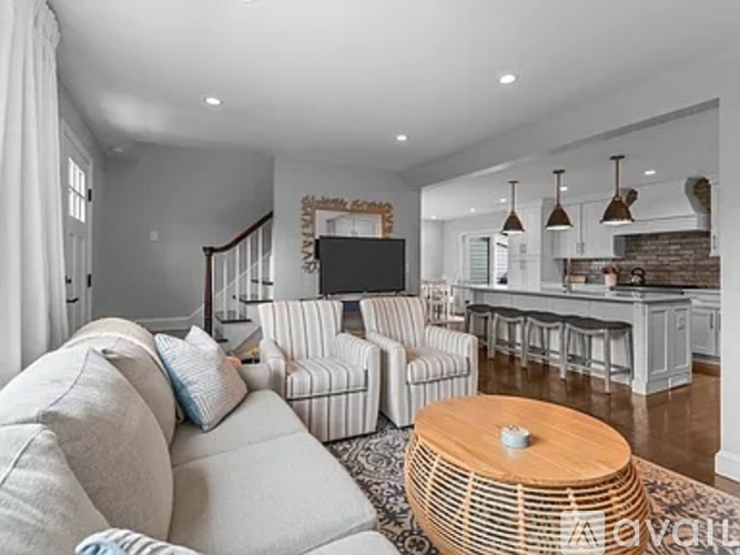 A living room with a white couch and a wooden coffee table.