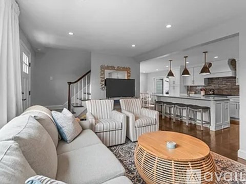 A living room with a white couch and a wooden coffee table.