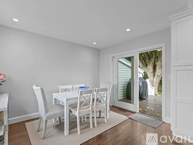 A dining room with a white table and chairs.
