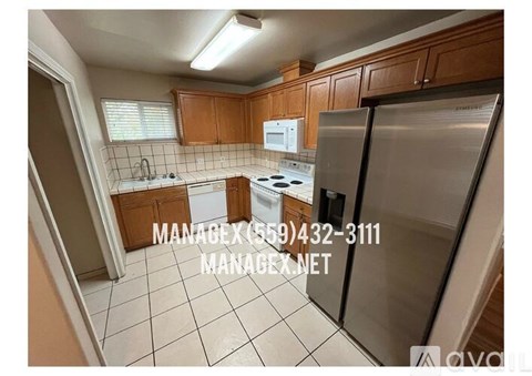 A kitchen with a refrigerator, stove, and microwave.