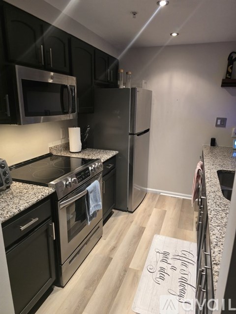 A kitchen with black cabinets and a stove top oven.