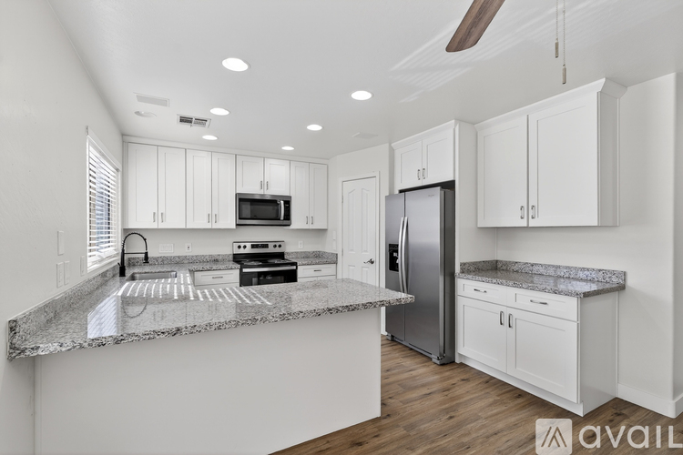 A modern kitchen with granite countertops and stainless steel appliances.